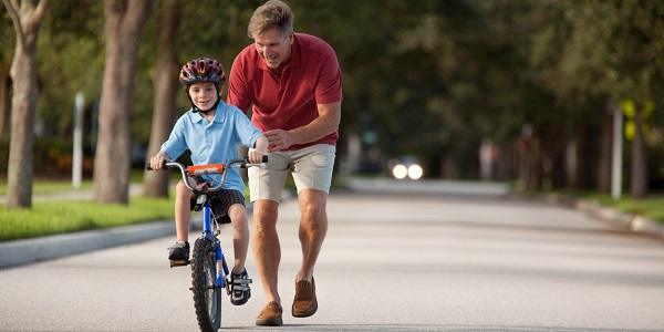 Father teaching son how to ride a bike